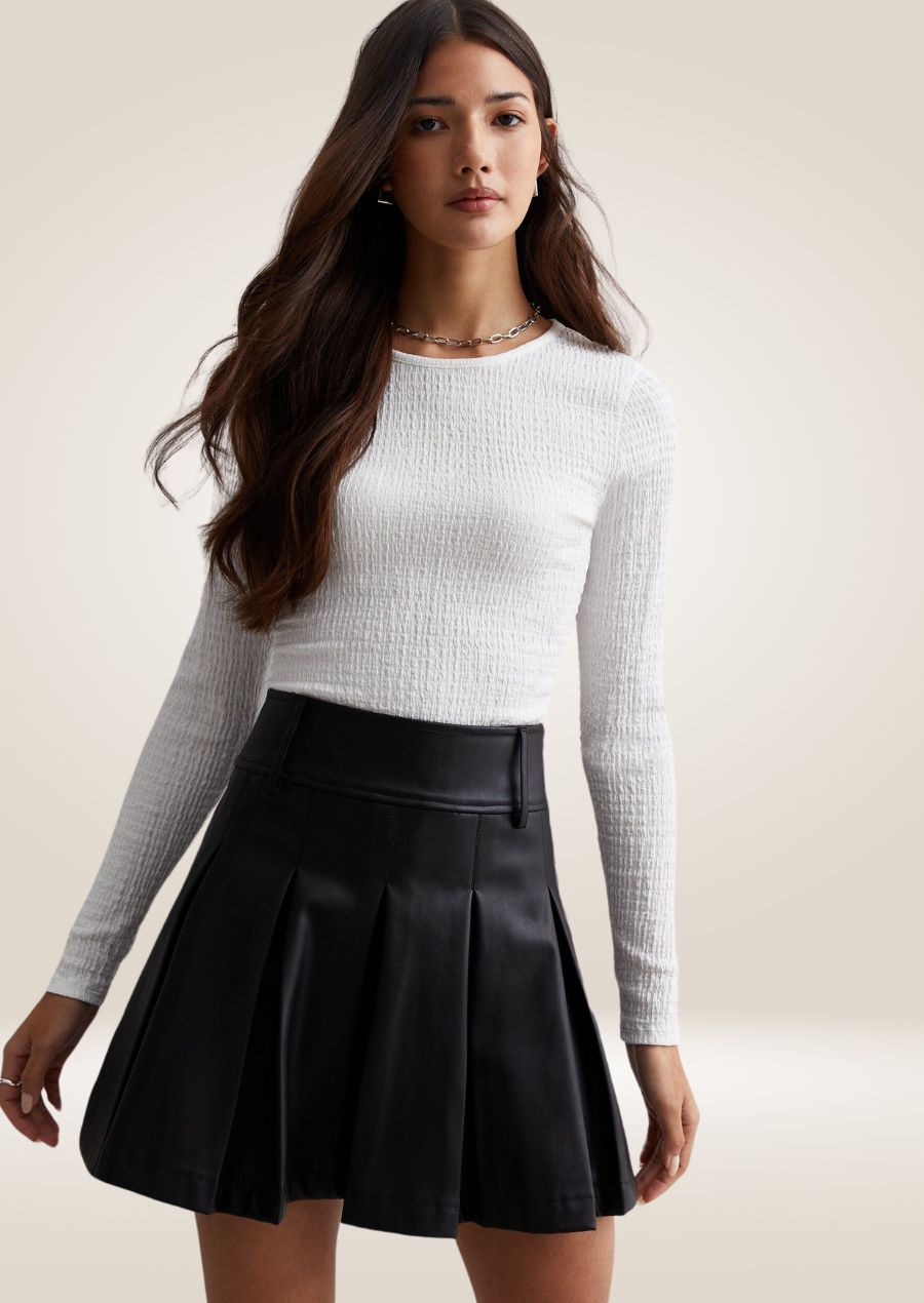 Black leather mini skirt with high waist and sleek tailored silhouette for modern styling